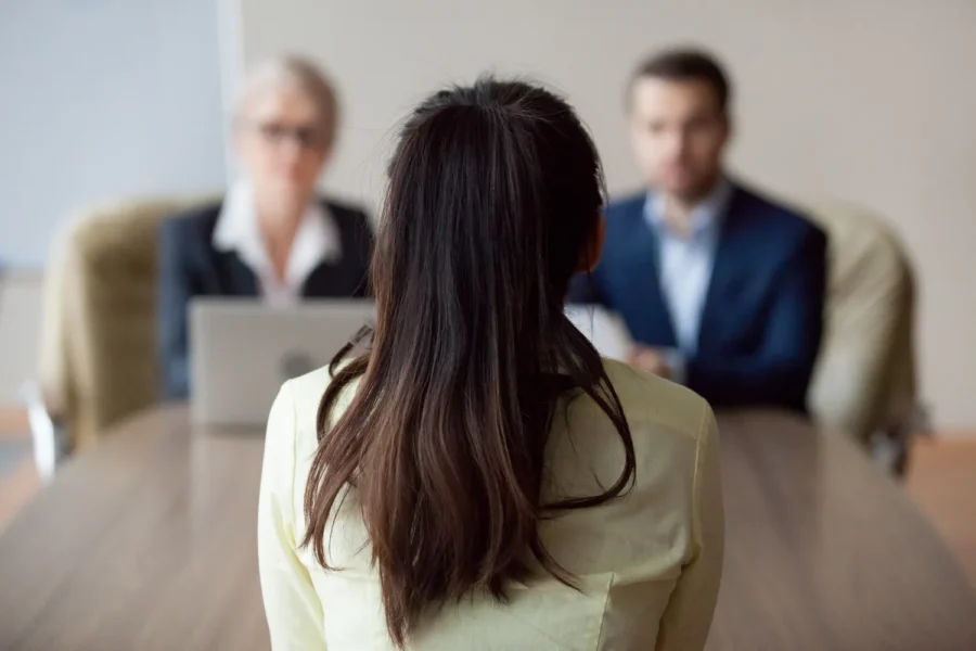 Job candidate in an interview with 2 hiring managers at an office table