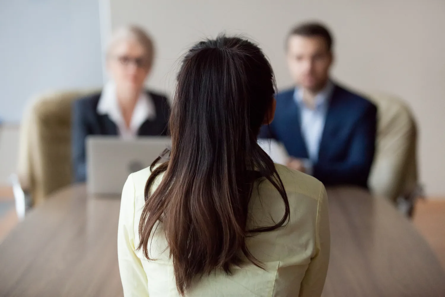 Job candidate in an interview with 2 hiring managers at an office table